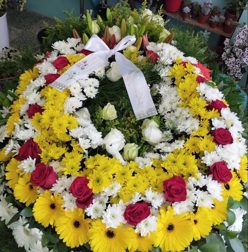 Coroa fúnebre com flores amarelas, brancas e vermelhas
